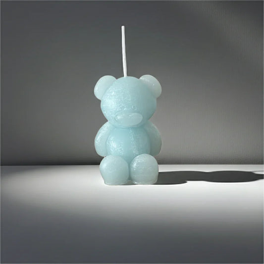 Handgemachte Kerze in Bärenform, hellblau, auf heller Fläche, dekorativ und nachhaltig