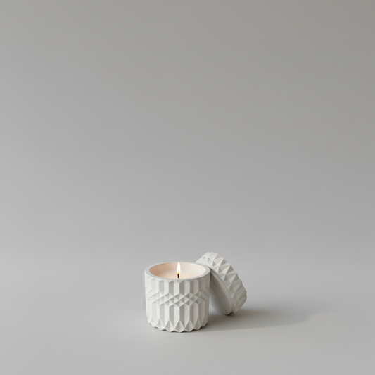 Handgemachte Kerze in weißem, strukturiertem Behälter mit Deckel, minimalistisch aufgestellt