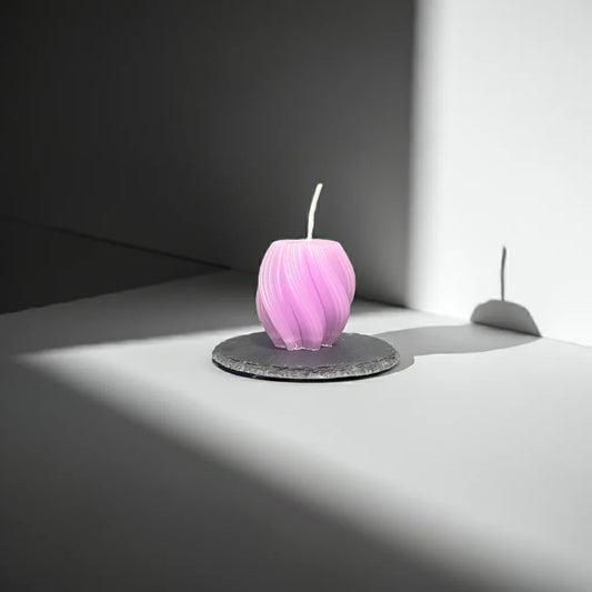 Handgemachte lila Kerze mit Spiraldesign auf rundem Steinteller im modernen Licht