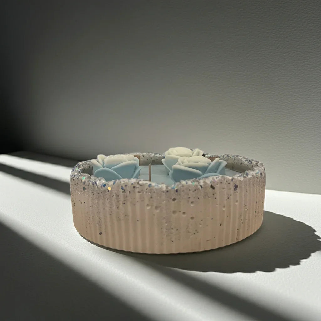 Handgemachte Kerze in runder Form mit blauen und weißen Blüten, dekorative Lichtquelle