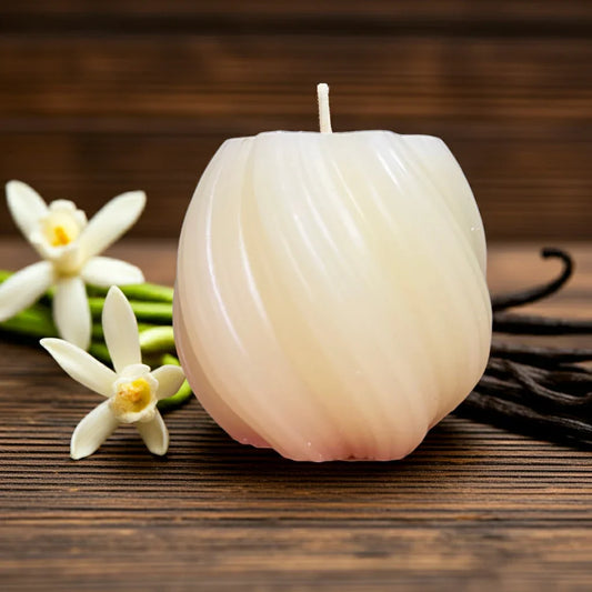 Handgemachte Duftkerze in hellem Wachs mit Vanilleblüten, auf Holzoberfläche