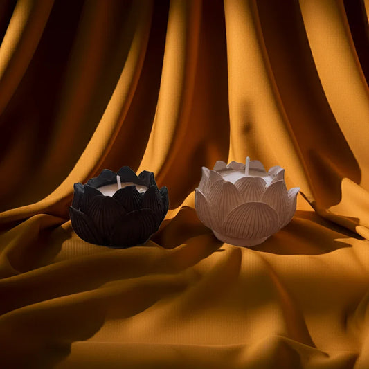 Handgemachte Kerzen in Lotusblütenform auf goldenem Stoff, stimmungsvolles Licht