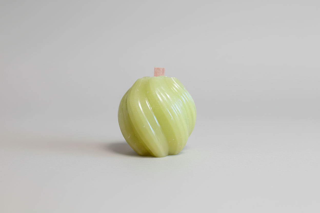 Handgemachte grüne Kerze mit Holzdocht, modern gewundene Form auf hellem Hintergrund