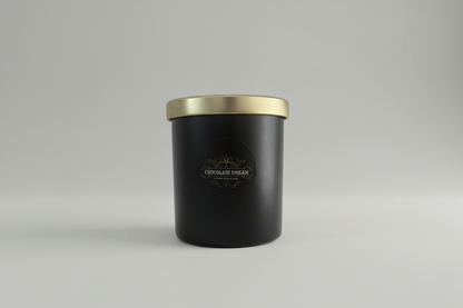 Schwarze Duftkerze im Glas mit goldenem Deckel und Aufschrift Chocolate Dream, minimalistisch.