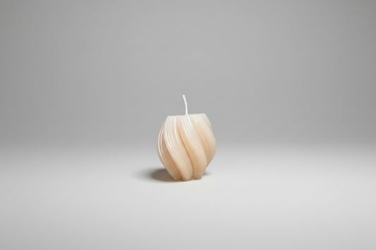 Handgemachte, beige Kerze mit Spiraldesign auf neutralem Hintergrund