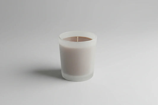 Handgemachte Duftkerze im matten Glas, minimalistisch auf hellem Hintergrund