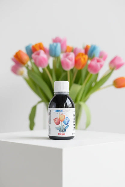 Duftöl-Flasche Tulpen auf weißem Podest, bunter Tulpenstrauß im Hintergrund