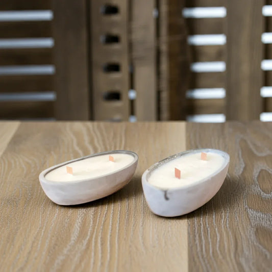 Zwei handgemachte, ovale Kerzen mit Holzdocht auf Holztisch, minimalistisch dekorativ