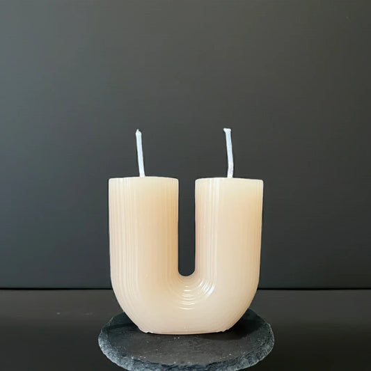 Handgemachte Kerze in U-Form mit zwei Dochten auf dunklem Untergrund, moderne Deko